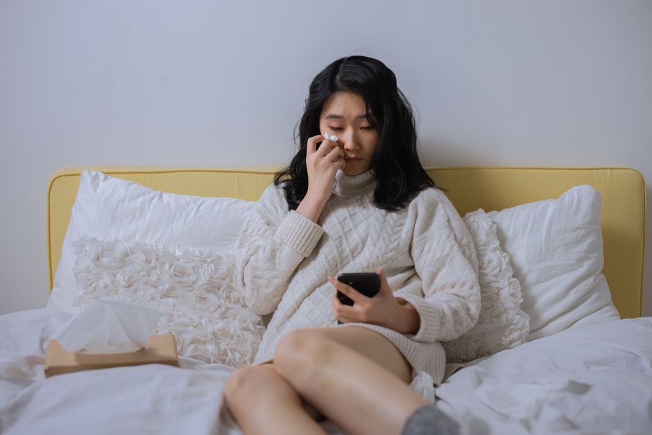 スマートフォンを握りしめる女性