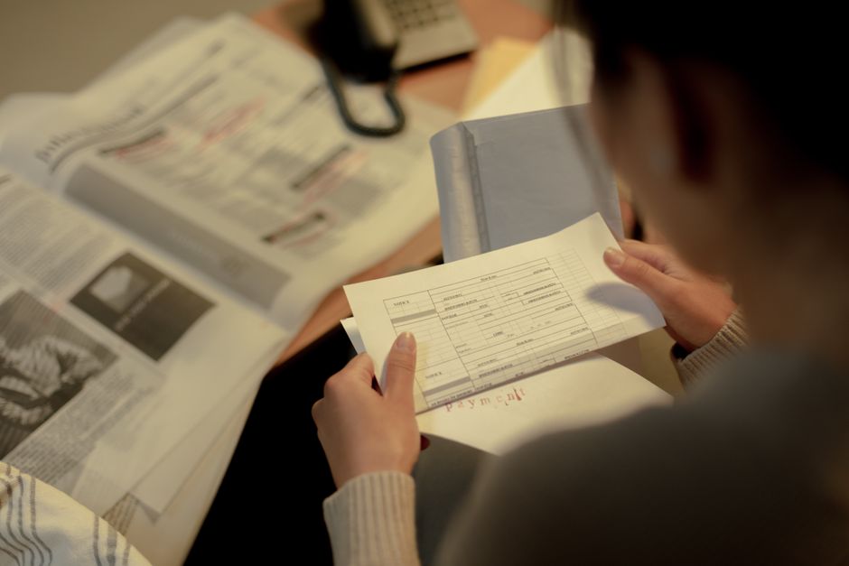 一人で書類を調べる女性の後ろ姿