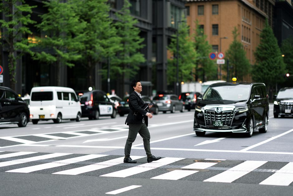 公道を歩く日本人男性の後ろ姿