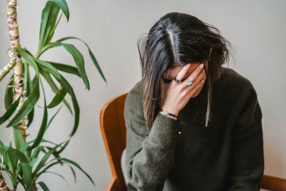 ひとりで頭を抱え思い悩む女性