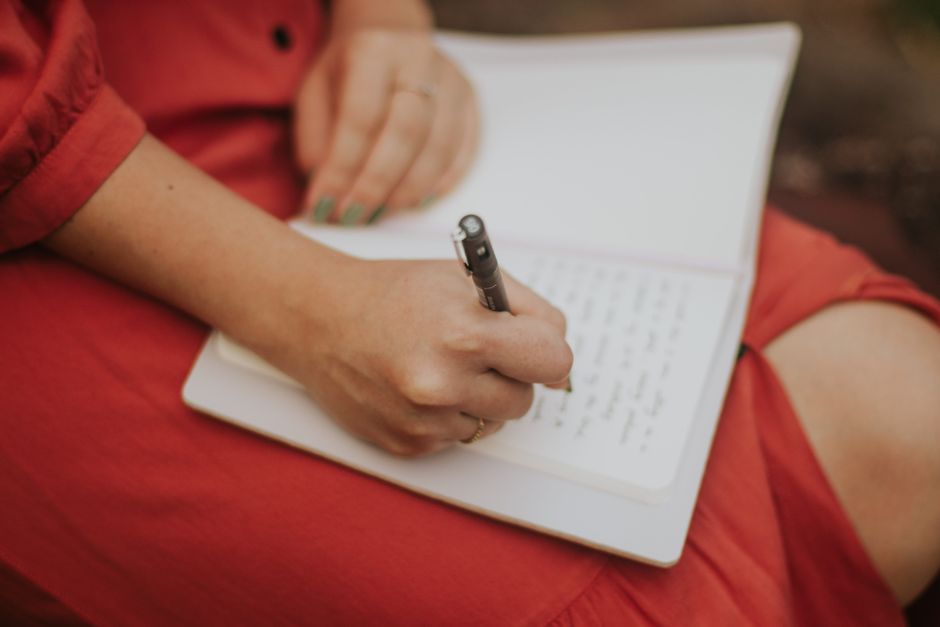 紙に経緯を書き出し気持ちを整理する女性