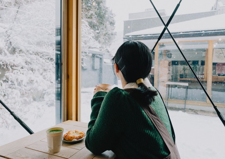 カフェでコーヒーを見つめる女性