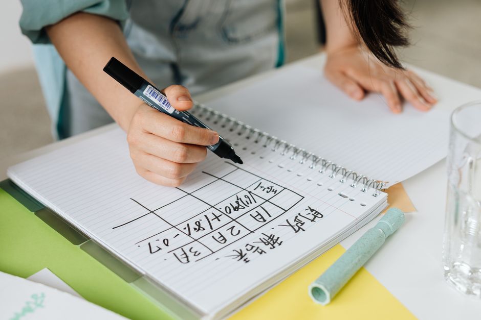 ノートに書き留める女性の手元