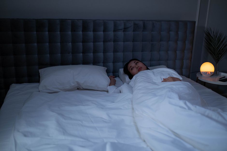 眠れず夜に横たわる女性