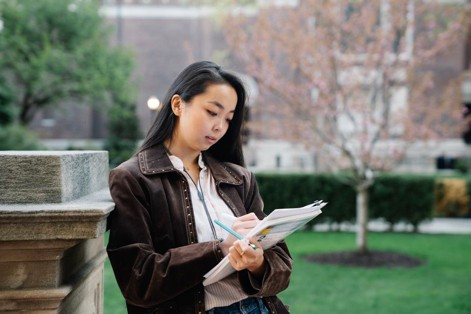 メモを取りながら書類を確認する女性