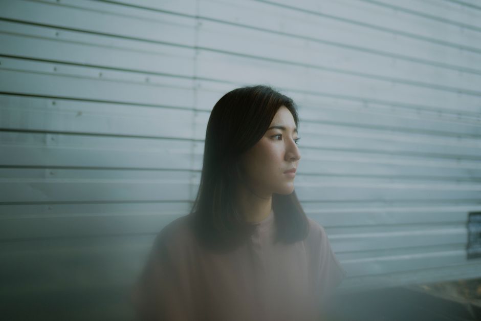 窓の外を眺めながら心情を整理している女性