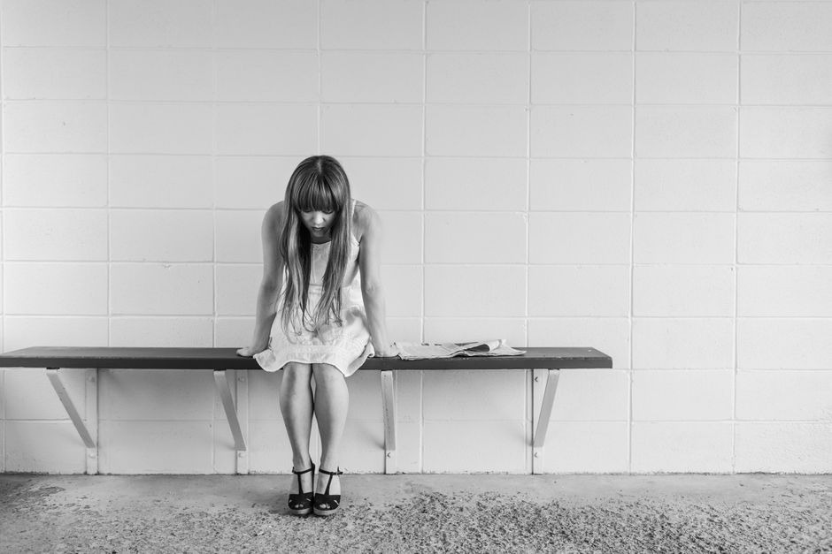 葛藤している女性が思い詰めた表情で座っている様子