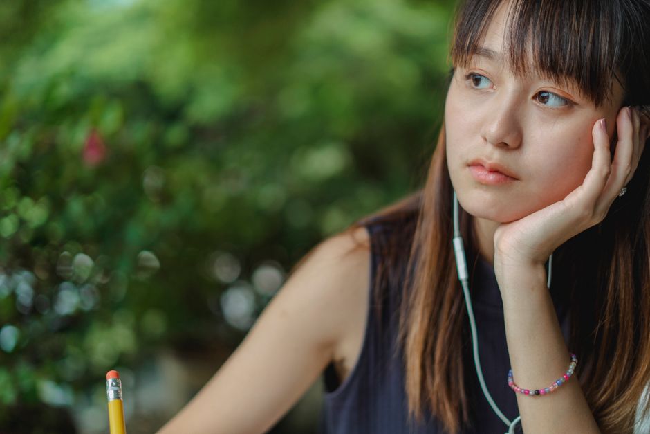 紙にペンで書きながら落ち着きを取り戻す日本人女性